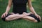 cropped image of Ð’Â woman practicing yoga in lotus pose on grass